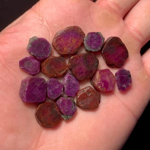 Puede incluir: Una taza de cerámica blanca con un asa negra y el texto "But First, Coffee" en negrita negra. La taza se encuentra sobre un fondo borroso, resaltando su diseño sencillo.