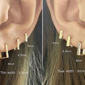 Puede incluir: Tres aros de oro de diferentes tamaños, 5 mm, 6,5 mm y 8 mm. Los pendientes se muestran en la oreja de una persona. El texto "Thin width: 1.5mm" está debajo de los pendientes más pequeños. El texto "Thick width: 3mm" está debajo de los pendientes más grandes.