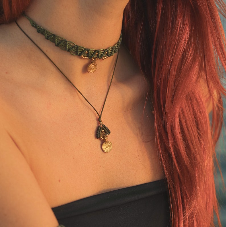 May include: A woman wearing a green macrame choker necklace with a gold pendant and a matching longer necklace with a gold pendant.