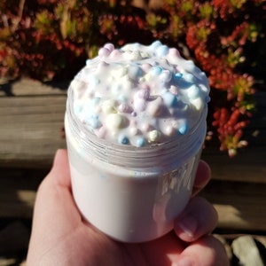 May include: A clear jar filled with white slime with colourful sprinkles. The slime is thick and fluffy, and the sprinkles are scattered throughout.