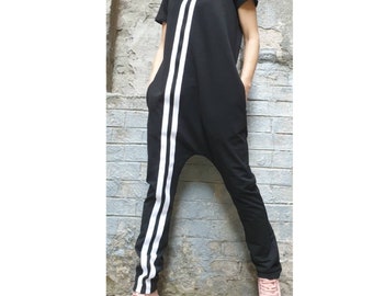 May include: Black jumpsuit with white stripes down the legs. The jumpsuit has a hood and short sleeves.