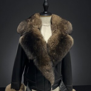 May include: Black leather jacket with a large brown fur collar and cuffs. The jacket has a belted waist and a zipper closure. The jacket is displayed on a mannequin.