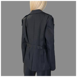 Black tailored avant-garde jacket for women with decorative asymmetric straps and modern statement design.