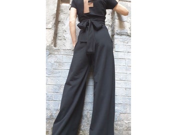 May include: Black wide-leg pants with a black top featuring a cut-out "F" on the back. The top has a black ribbon tied at the waist.