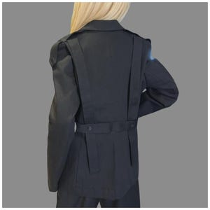 Back view of black avant-garde blazer with tailored fit, asymmetric strap design, and structured silhouette.