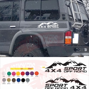 May include: Black and white decal sticker with the text "4x4 Sport Off Road" and a mountain range graphic. The sticker is shown on the back window of a grey SUV.