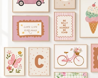 May include: A gallery wall set of framed art prints featuring illustrations of a pink car, a moon and stars, an ice cream cone, a butterfly, a bicycle with flowers, a letter C, and floral patterns with text reading Long Live Girlhood and Be Silly Be Honest Be Kind.
