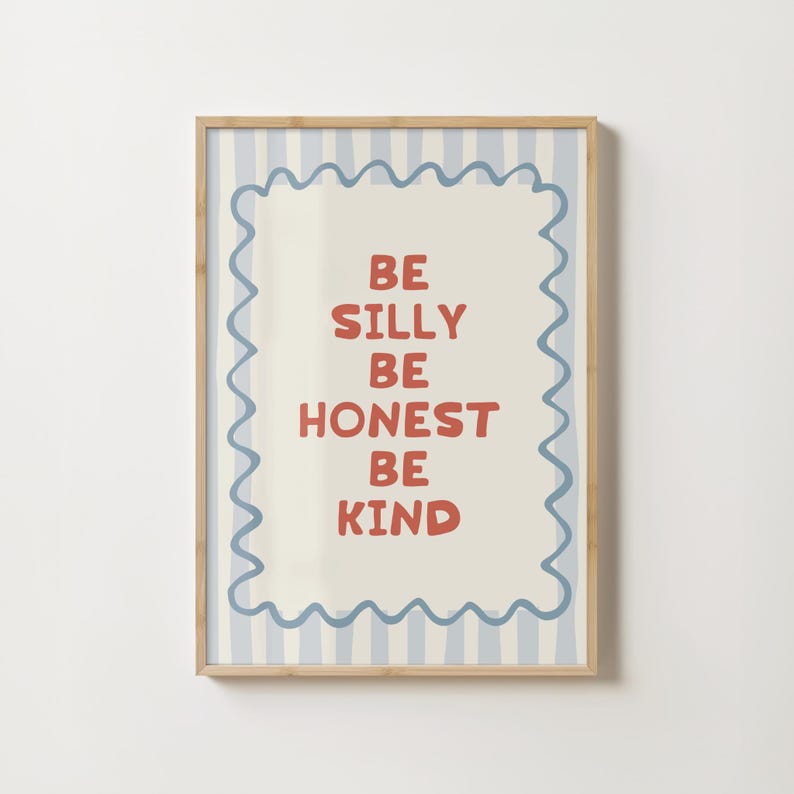 Puede incluir: Una impresi&oacute;n art&iacute;stica enmarcada con un fondo beige claro y un borde a rayas azules y blancas. La impresi&oacute;n presenta las palabras "BE SILLY BE HONEST BE KIND" en letras rojas. El marco es de color marr&oacute;n claro.