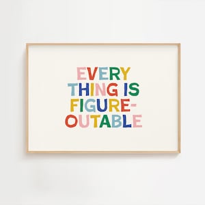 May include: A framed print with the text "EVERYTHING IS FIGURE-OUTABLE" in colorful, playful letters. The words are in pink, green, blue, red, yellow, and orange. The frame is a light wood color.