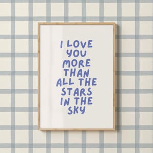 Może przedstawiać: Oprawiony wydruk z napisem "I LOVE YOU MORE THAN ALL THE STARS IN THE SKY" w niebieskich literach. Wydruk jest w drewnianej ramie i znajduje się na jasnoniebieskim i białym tle w kratę.