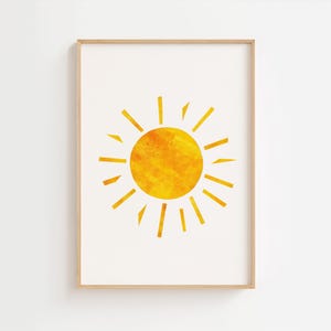 Può includere: Stampa artistica incorniciata con un sole giallo stilizzato su sfondo bianco. Il sole, dalla texture marcata, è circondato da raggi gialli. L'opera è presentata in una cornice di legno chiaro, adatta all'arredamento.