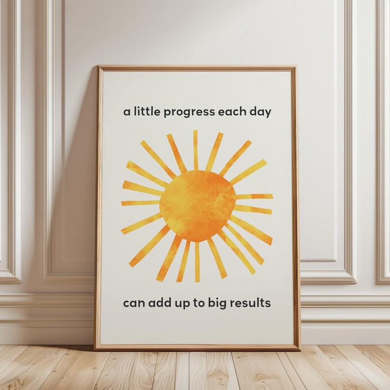 A sun inspired by Eric Carle's collage with a motivational quote for kids about growth mindset. The quote states: a little progress each day can add up to big results. A single frame on the floor is shown.