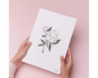 Op de afbeelding: Zwart-wit illustratie van een pioenroos en knop op wit papier. Het kunstwerk wordt door twee handen tegen een roze achtergrond gehouden. De tekening heeft gedetailleerde schaduwen en delicate lijnen, die de bloemblaadjes en bladeren van de bloem laten zien.
