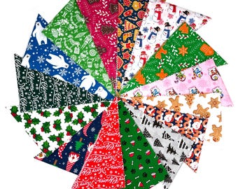 May include: A selection of Christmas-themed fabric bandanas in various colours and patterns. Designs include polar bears, snowmen, holly, gingerbread men, and the text "Merry Christmas". Each bandana is triangular in shape.