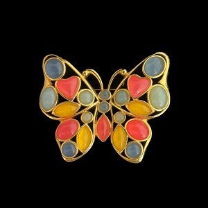 May include: A gold-tone butterfly brooch with colorful enamel accents. The butterfly has blue, yellow, pink, and red enamel details.