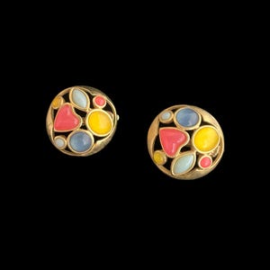 May include: A pair of gold tone earrings with colorful enamel stones in a circular design. The stones are in shades of pink, yellow, blue, and white.
