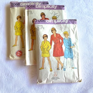 May include: Three sewing patterns for children's robes. The patterns are from Simplicity and are numbered 7066. The patterns include instructions for making robes in yellow, red, and blue.