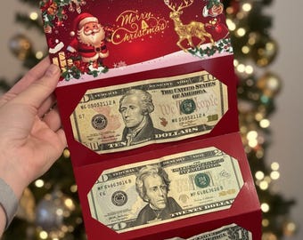 May include: A red Christmas card with the words "Merry Christmas" and illustrations of Santa Claus and a reindeer. The card holds a $10 bill and three $20 bills.
