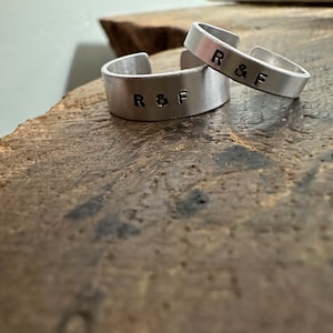 May include: Two silver rings, each inscribed with "R&F".