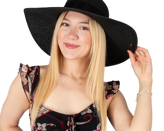 Puede incluir: Una mujer con un sombrero de sol negro de ala ancha y un vestido floral negro y rojo.