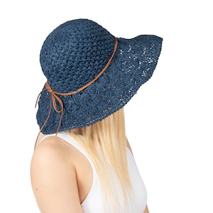 May include: A blue crochet sun hat with a brown leather band. The hat has a wide brim and is made of a lightweight material.