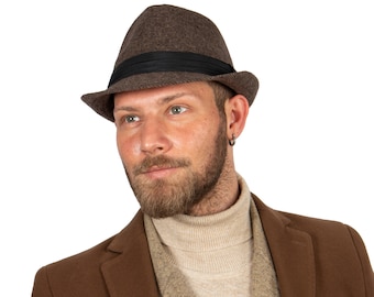 May include: A man wearing a brown fedora hat with a black band, a brown turtleneck sweater, and a brown jacket.