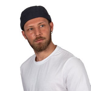 以下が含まれることがあります： 紺色のビーニーと白いTシャツを着た男性