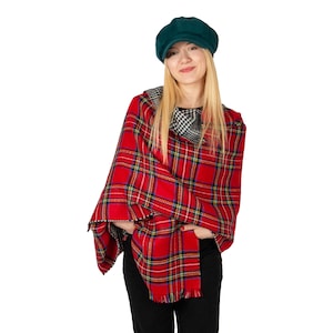 Peut inclure: Une femme portant un poncho rouge et noir à carreaux avec un béret vert. Le poncho a une bordure noire et blanche autour du cou.