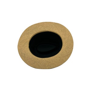 May include: A tan straw hat with a black fabric lining. The hat is viewed from the inside.