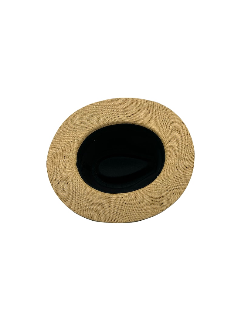 May include: A tan straw hat with a black fabric lining. The hat is viewed from the inside.