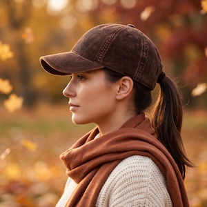 May include: A dark brown corduroy baseball cap with a structured crown and a curved brim. The cap features a classic six-panel design with visible stitching along the seams and a button at the top, providing a textured finish to the fabric.
