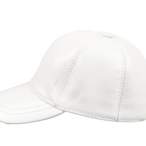 Può includere: Un cappellino da baseball in pelle bianca con visiera curva. Il cappellino ha una corona arrotondata ed è realizzato in pelle liscia e cucita. Il cappellino è di colore bianco pieno ed è posto su uno sfondo bianco.