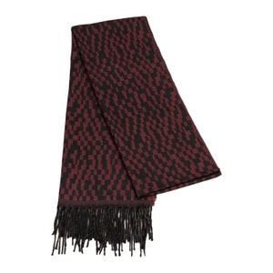 May include: A burgundy and black patterned scarf with fringe on the ends.