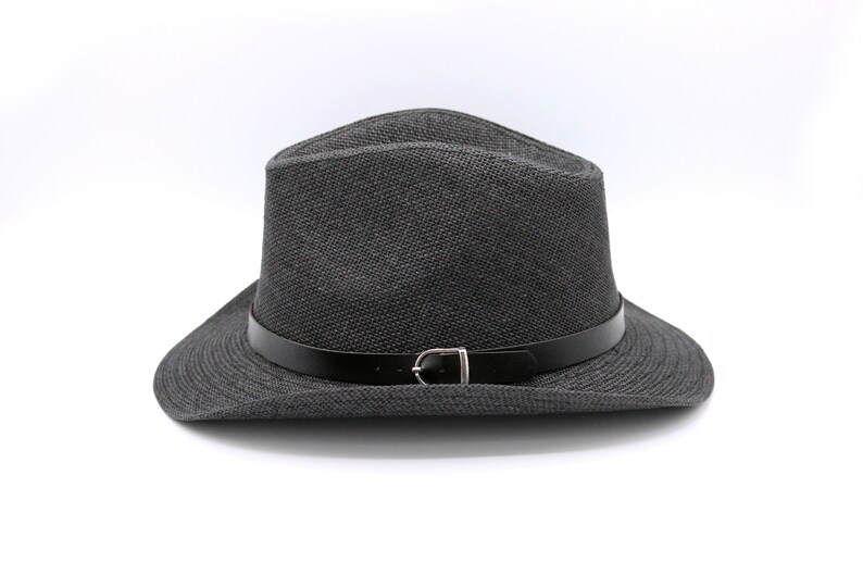 K&ouml;nnte beinhalten: Ein schwarzer Fedora-Hut mit einem schwarzen Lederband und einer silbernen Schnalle.