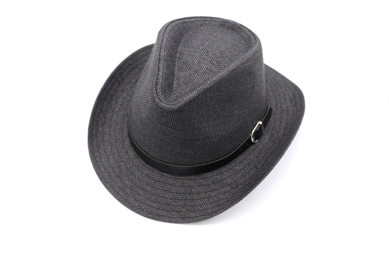 K&ouml;nnte beinhalten: Ein grauer Fedora-Hut mit einem schwarzen Lederband und einer silbernen Schnalle.