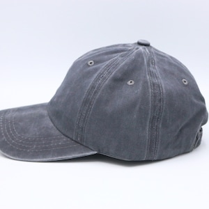 May include: A grey cotton baseball cap with a slightly distressed look. The cap has a curved brim and a structured crown.