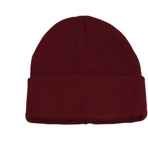 May include: A solid maroon beanie hat. The hat is made of a knitted material and features a folded cuff. The beanie is a classic style, suitable for cold weather and casual wear.