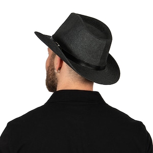 K&ouml;nnte beinhalten: Ein schwarzer Fedora-Hut mit breiter Krempe und einem schwarzen Band um die Krone.
