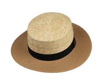 May include: A straw hat with a wide brim and a cylindrical crown. The crown is a light beige color, while the brim is a darker tan. A black band encircles the base of the crown. The hat is designed for sun protection.