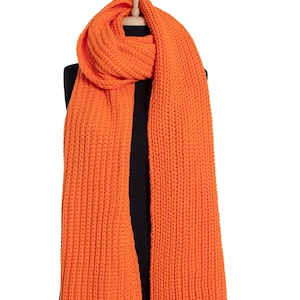 May include: A long, orange knitted scarf with a ribbed texture.