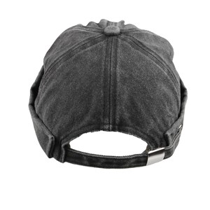 May include: A dark gray, washed-look baseball cap with a curved brim and adjustable strap. The cap features a button on top and a metal buckle closure at the back. The hat is made of a soft, textured fabric.