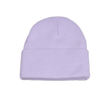 Puede incluir: Un gorro de punto de color lila claro hecho de tejido de punto suave.