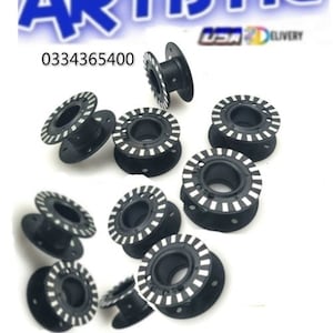 May include: Ten black plastic bobbins with white stripes. The bobbins are used for sewing and have a hole in the center for thread.