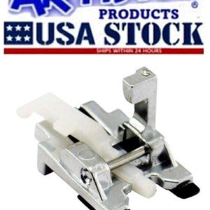 May include: A silver sewing machine foot with a white plastic component and black accents. The image includes the text "ARTISTIC PRODUCTS USA STOCK".