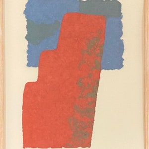 May include: An abstract art print with a red, blue, and gray color scheme. The print features a red shape with a textured surface and a blue and gray shape in the background. The print is signed and numbered.