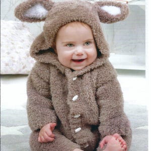 May include: A baby in a brown teddy bear costume with a hood and ears, and white buttons. The costume is made of a soft, fluffy material. The text "Wendy Peter Pan" is visible at the top of the image. The costume is designed for babies with a chest size of 41-56 cm.