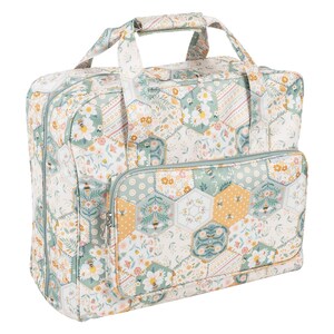 May include: A floral patterned sewing machine tote bag with a top handle and a front pocket. The bag features a patchwork design with hexagonal patterns, bees, and flowers in shades of white, green, and yellow.