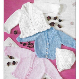 May include: A knitting pattern showing three baby cardigans in white, pale blue, and pink. The cardigans have button fastenings and V-necks. A matching white bonnet is also included. The text "Peter Gregory Designs for knitting" is visible.