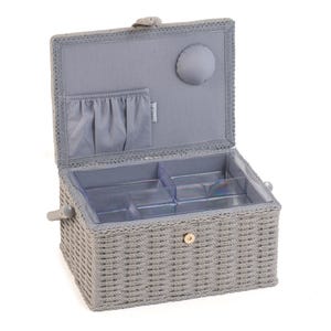 K&ouml;nnte beinhalten: Eine graue, gewebte N&auml;hkiste mit offenem Deckel. Der Innenraum verf&uuml;gt &uuml;ber ein hellgraues Stofffutter, eine kleine Tasche und transparente Kunststofff&auml;cher. Die Box hat einen Griff und einen Verschluss.