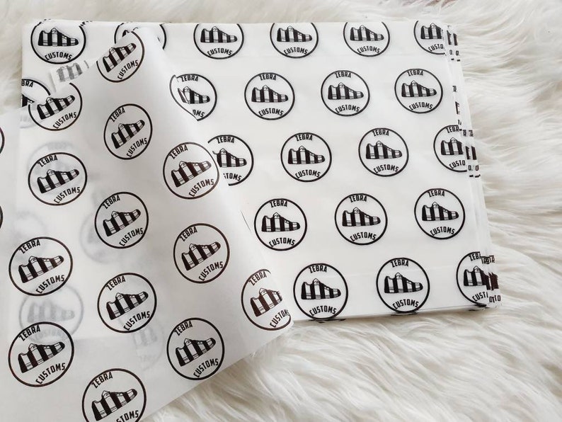May include: White tissue paper with a repeating pattern of black and white zebra print shoe logos with the text "Zebra Customs".
